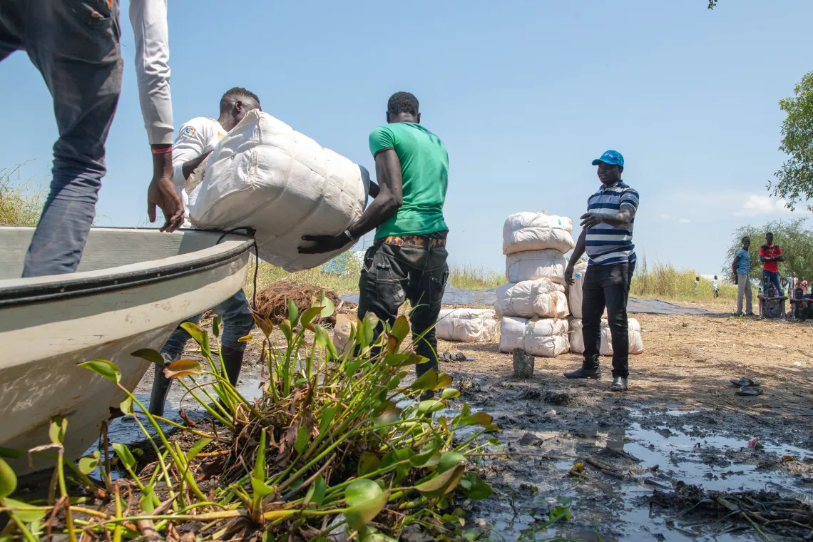 Men carrying mosquito nets from the boat