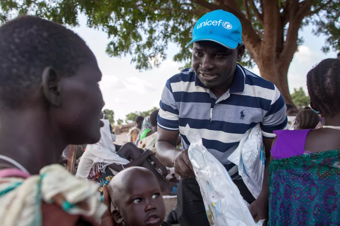 A UNICEF worker is handing out mosquito nets