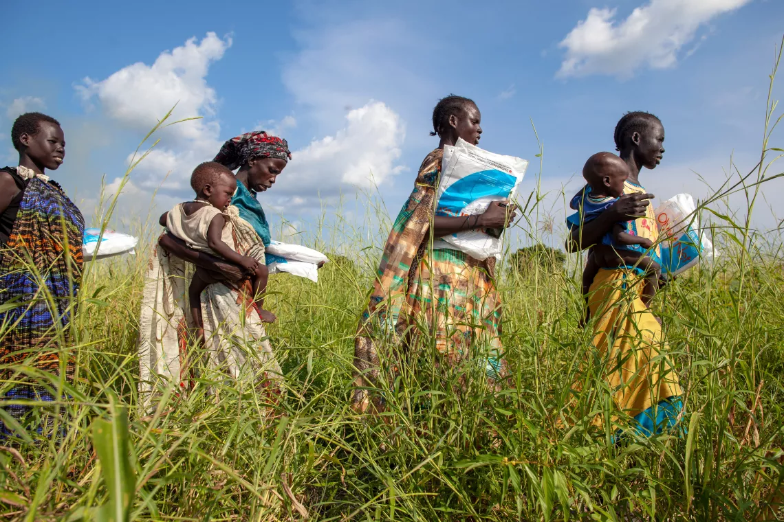 Women walking with mosquito nets in their hands