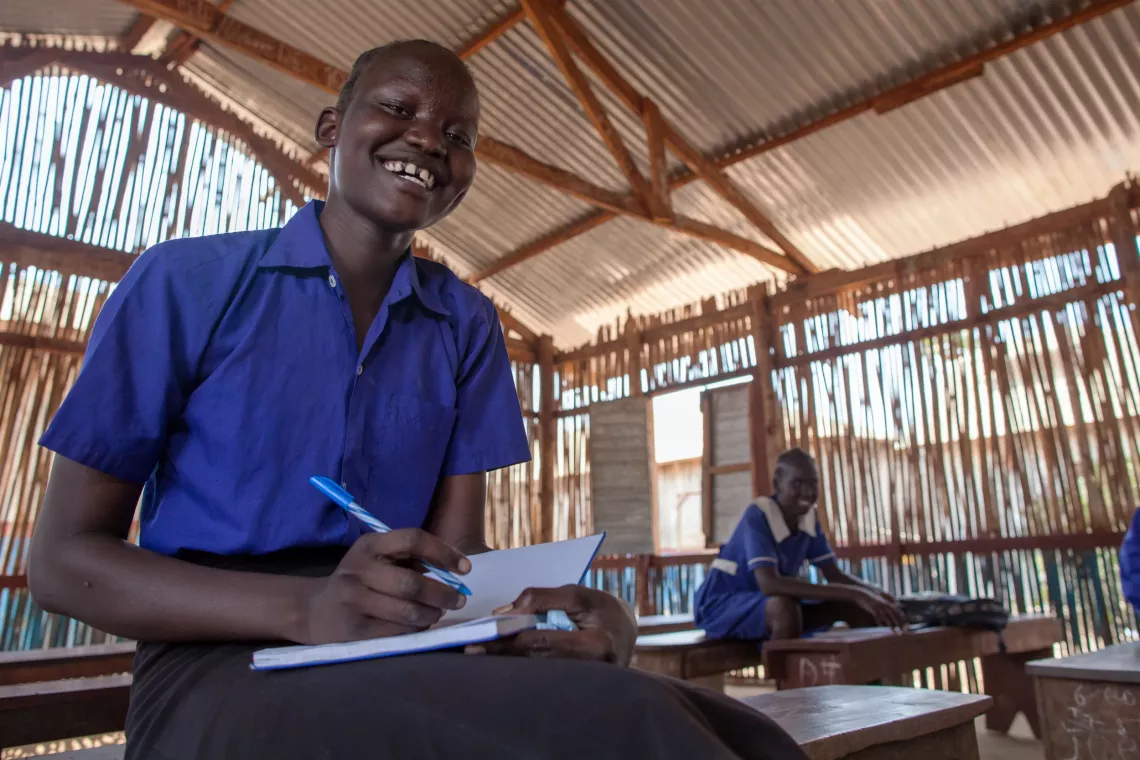 A girl student writing while sitting in a classroom in Juba South Sudan