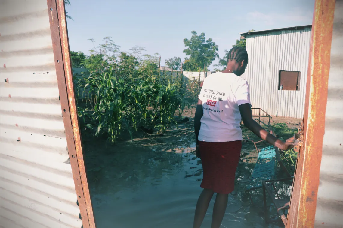 Woman opening gate to flooded house