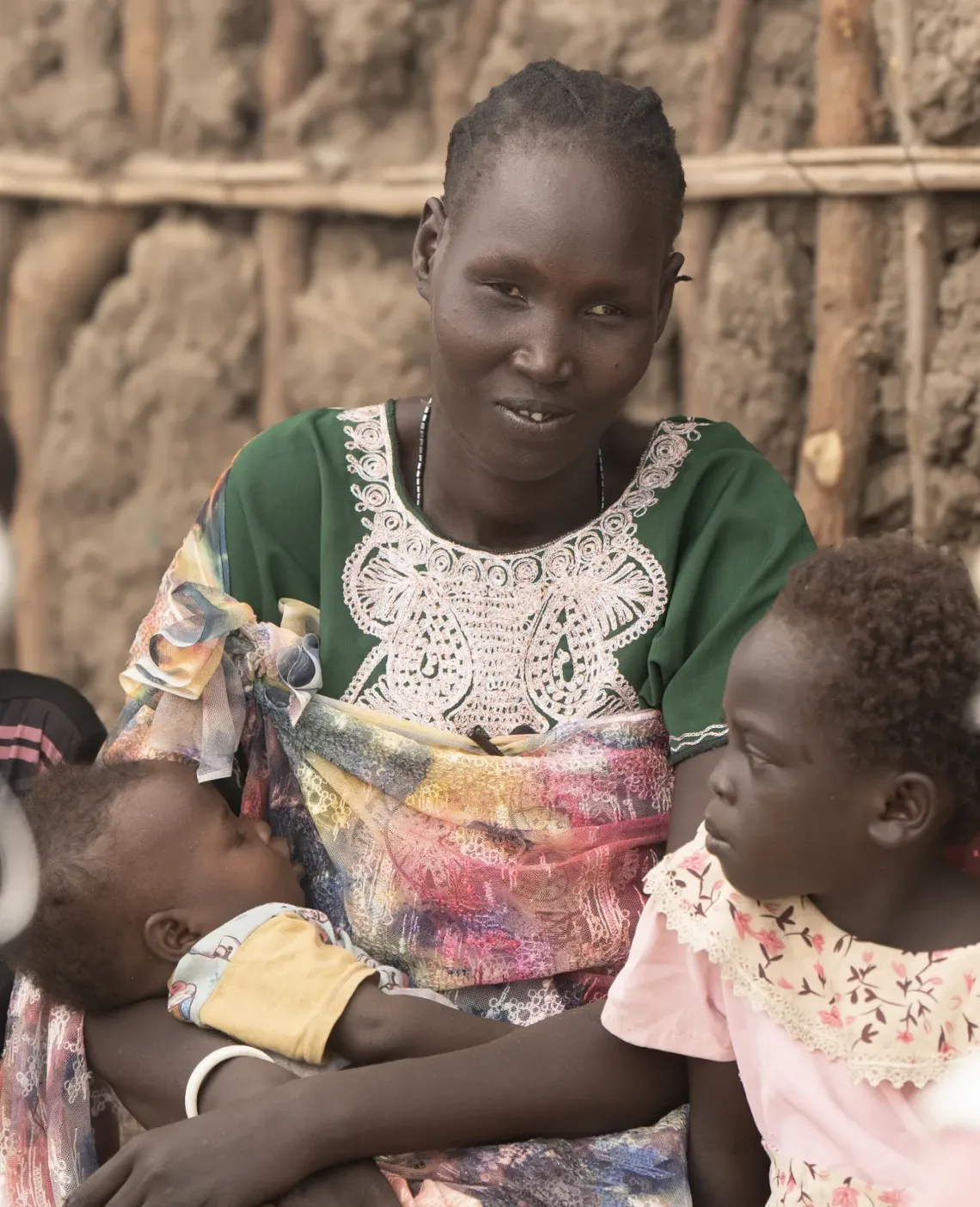  Nyageme, 38 years, sits outside her newly constructed house with her four daughters, in the Bor IDP camp.