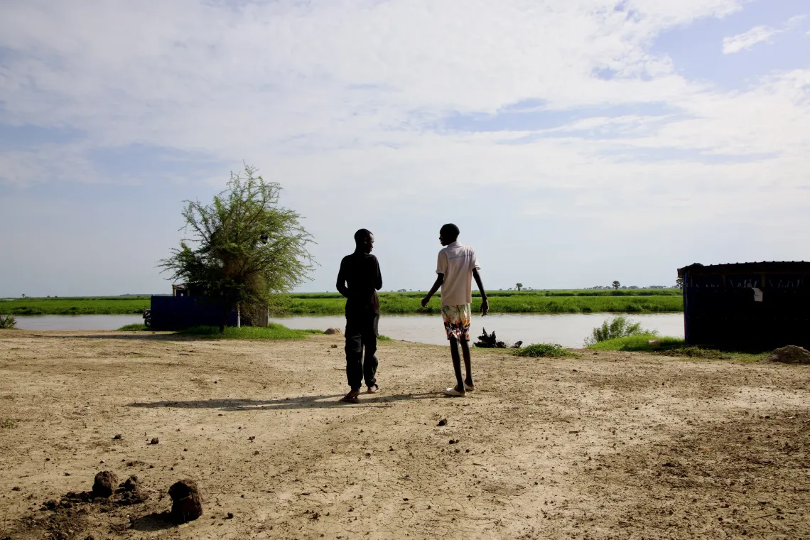 Jal (left) and his new friend, John Tut walk along the banks of the River Nile in Malakal near the Youth and Adolescent Centre