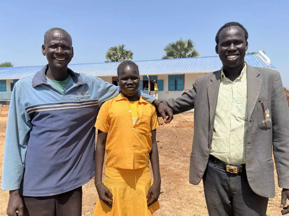 Head of PTA, pupil, and senior teacher are photographed in a school in South Sudan