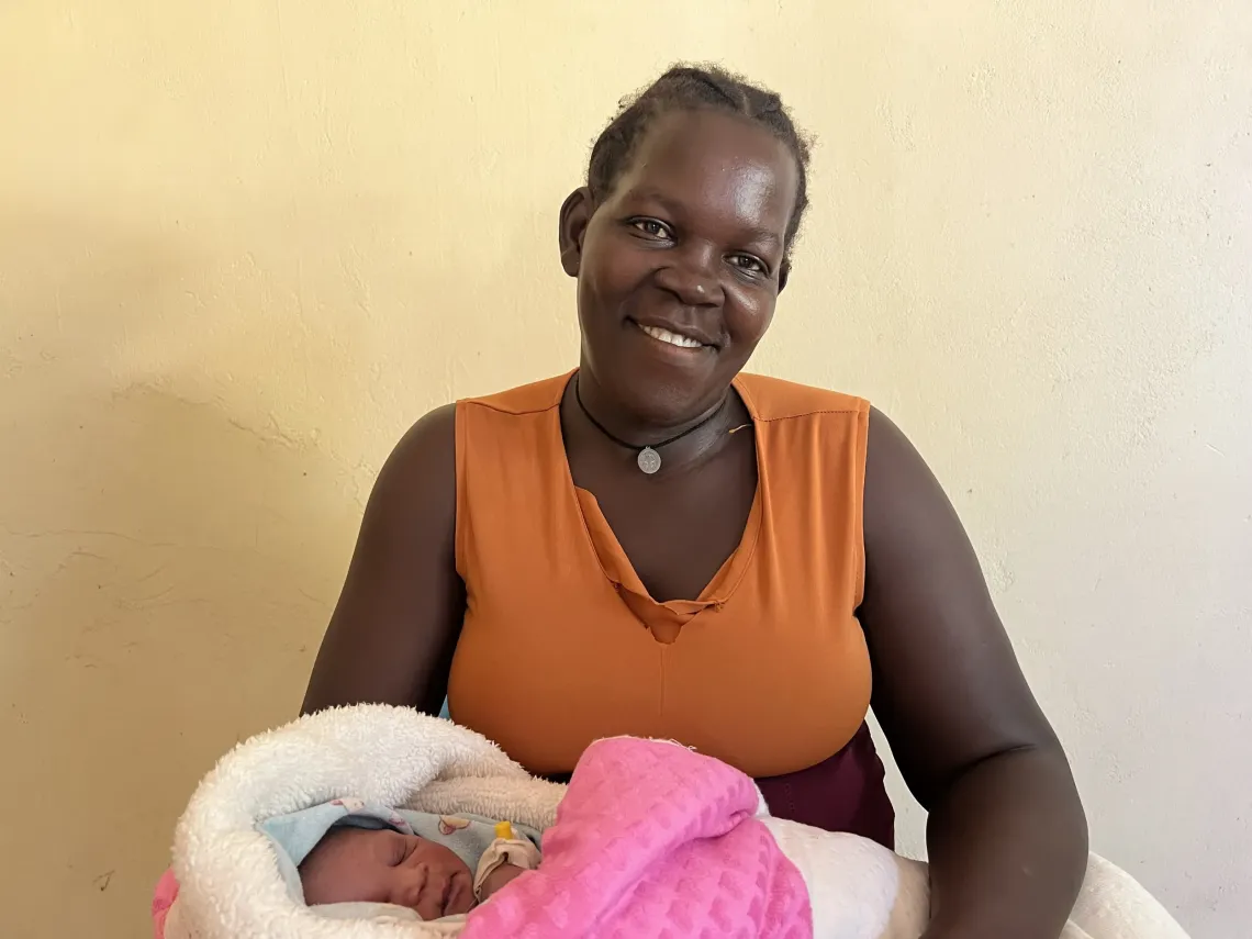 Winnie Mawut is sitted and holding her baby at the Bor Hospital, South Sudan