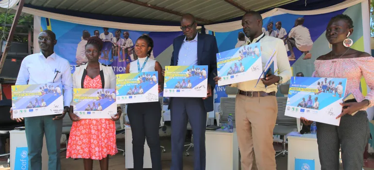Undersecretary, Ministry of general Education and Instruction, Honorable Dr. Kuyok Abol Kuyok, UNICEF South Sudan chief of communication, UNICEF young reporter, teachers, EU delegate holding a placard in support of more investment in teachers in South Sudan