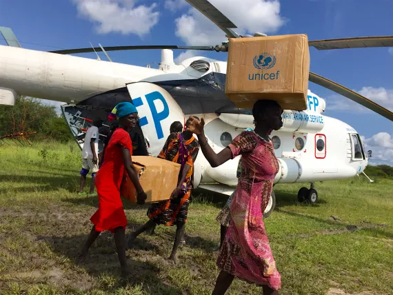 Women offloading UNICEF supplies from a WFP helicopter 