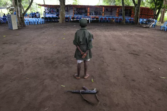 A boy standing in front of a gun