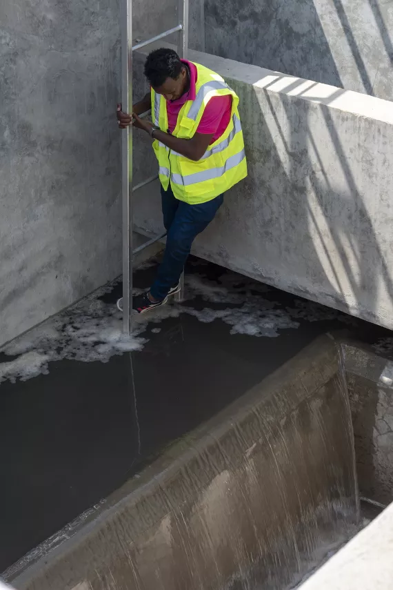 Tesfay standing on a ladder above the section where the filtration process is conducted