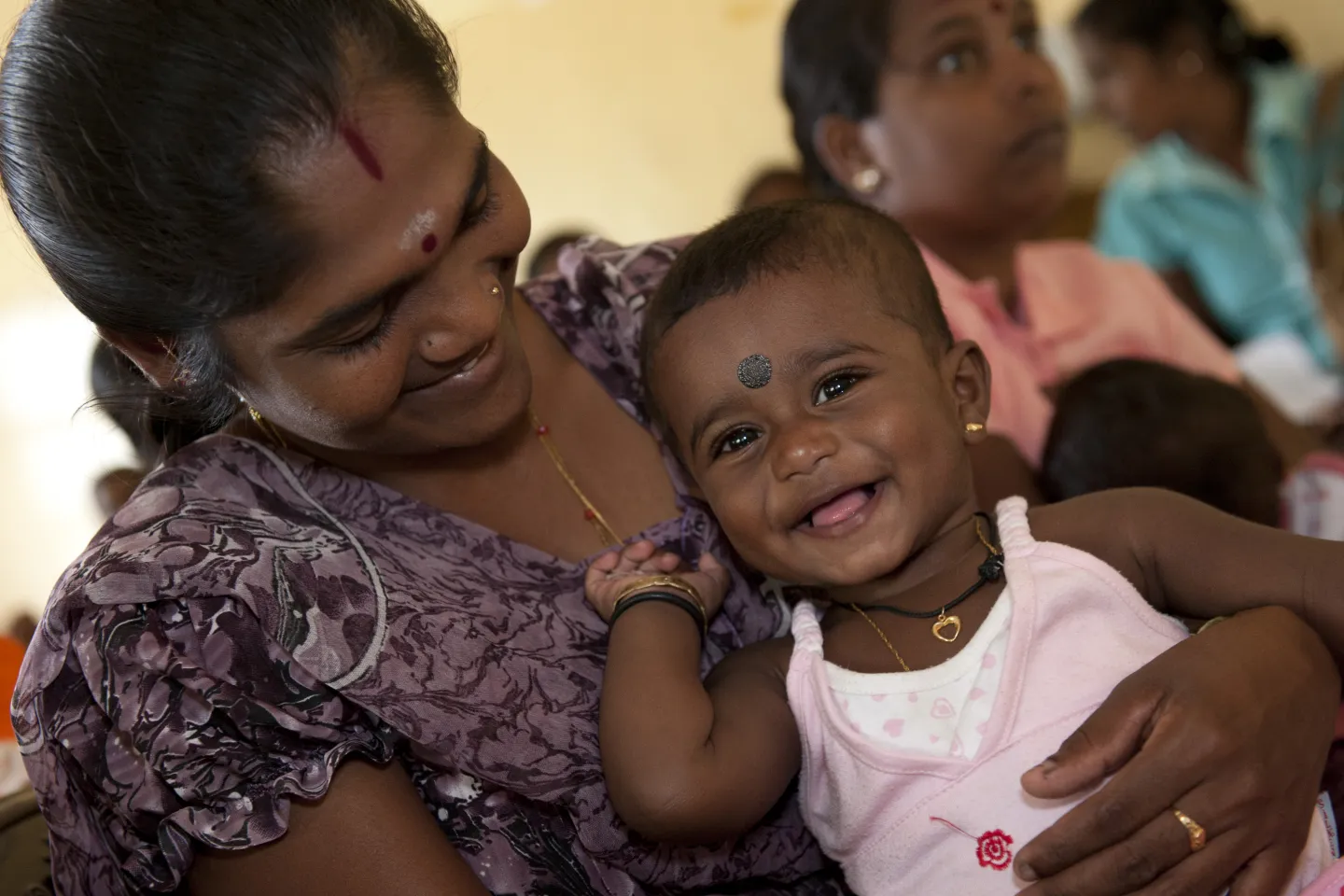 Baby in with a happy smiles in mothers protection.