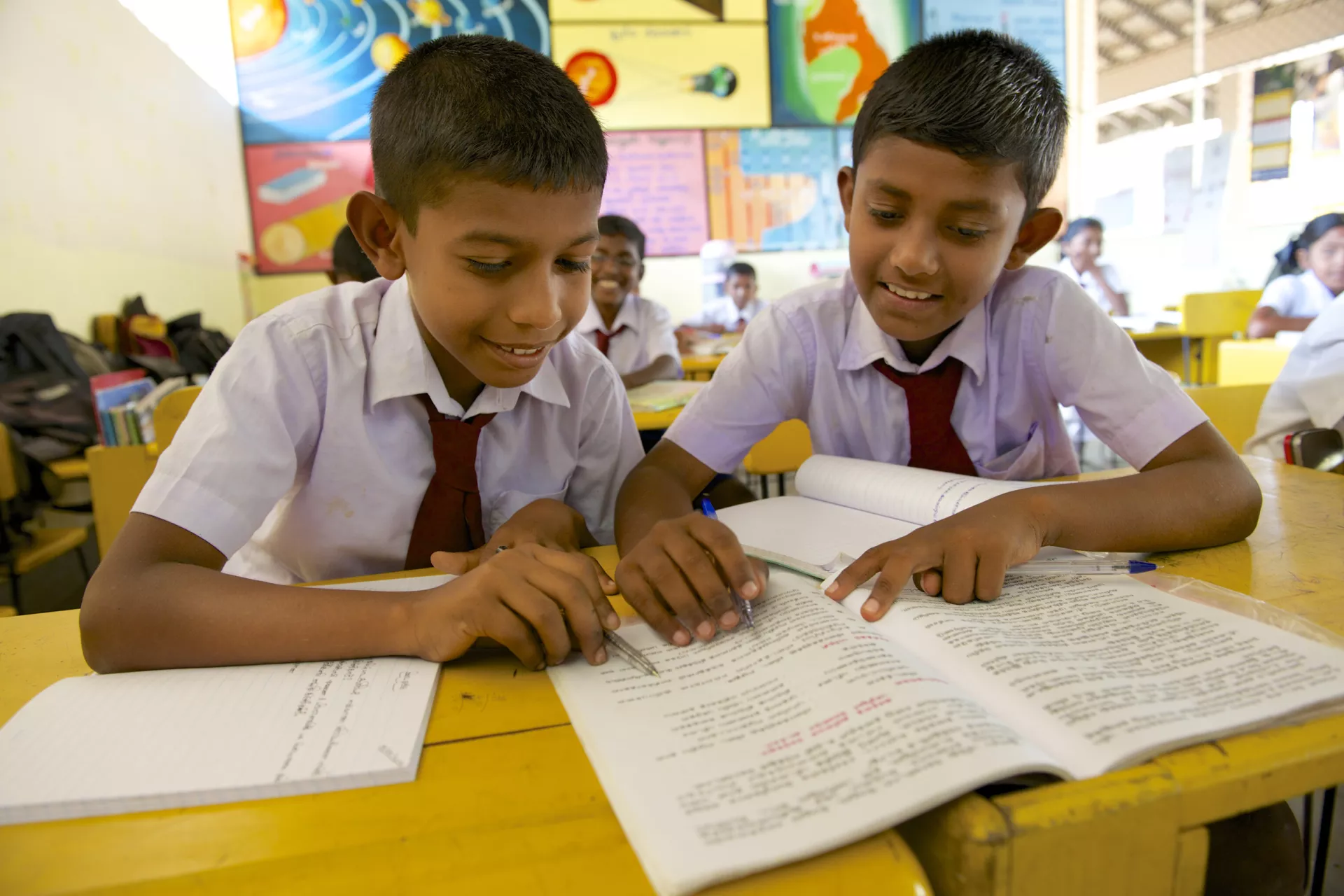 two boys sharing a text book