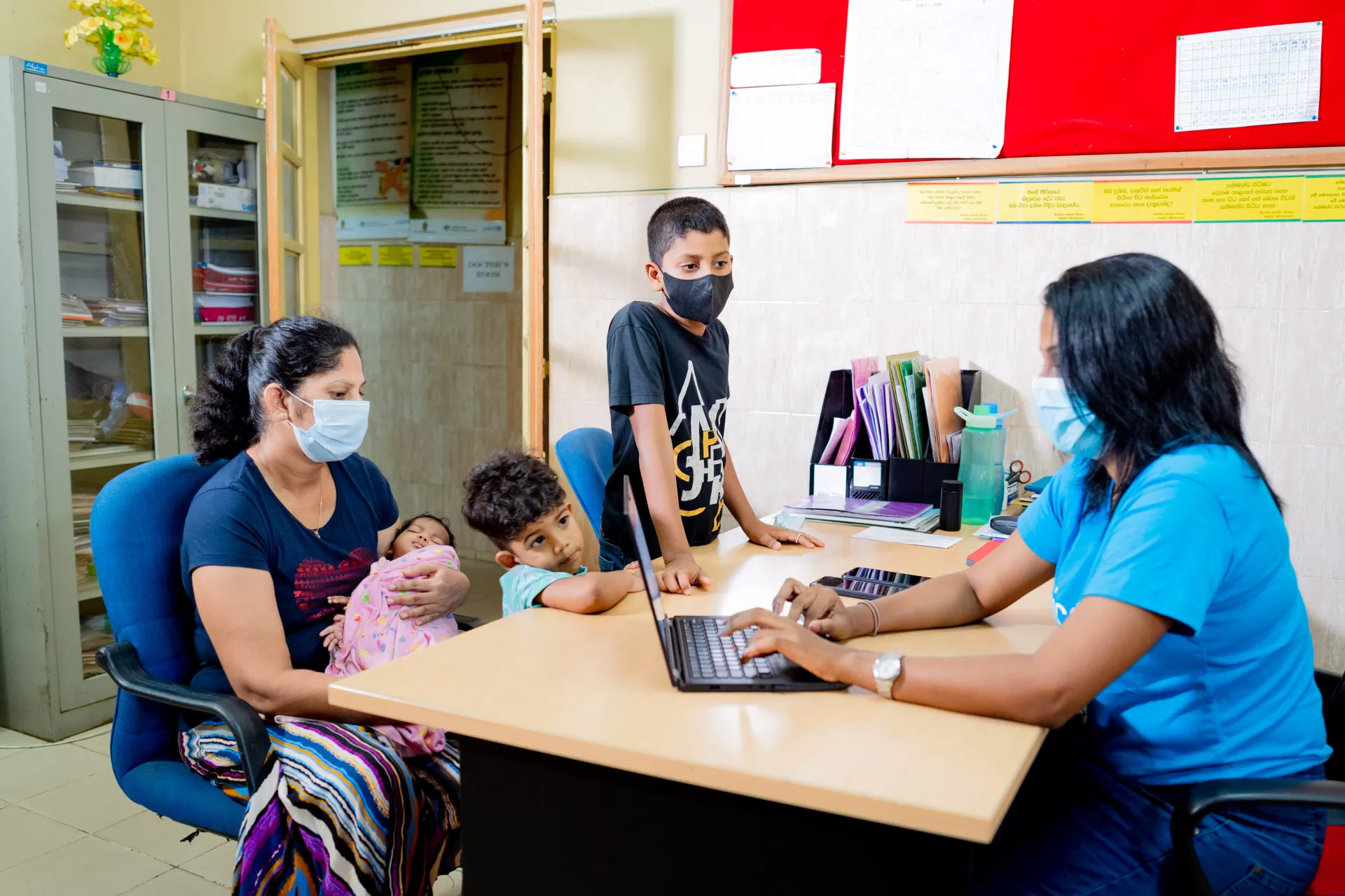 Tharushi (left) registering herself at the local health clinic