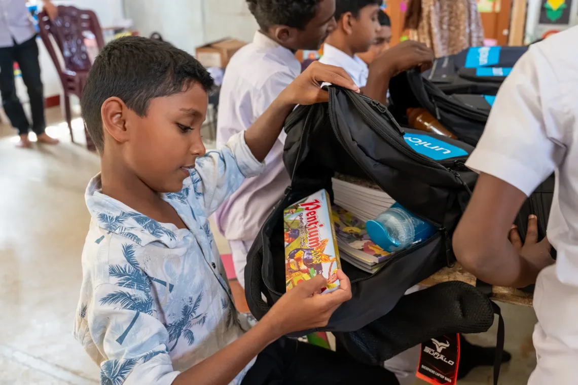 Child is opening up and checking whats in his bag