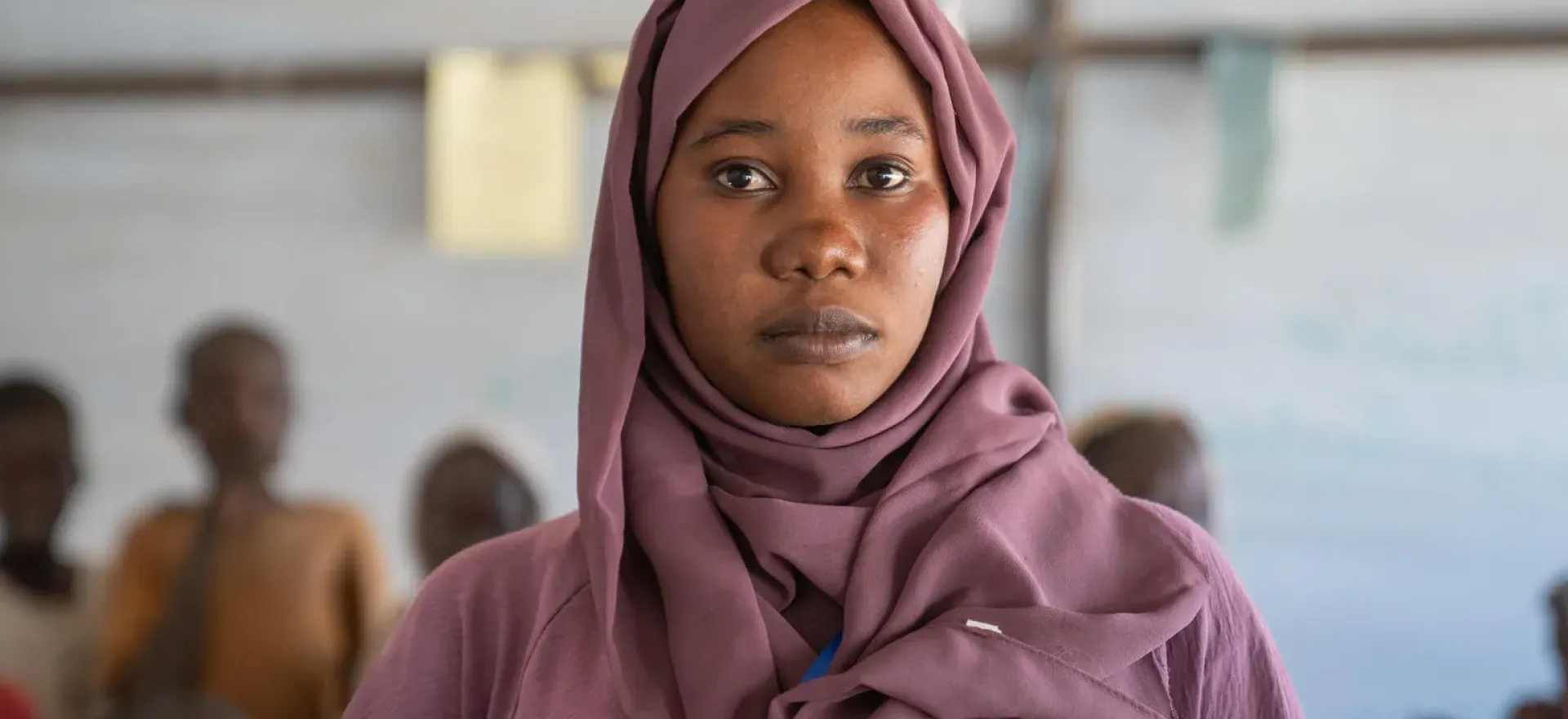 Sudan. Latifa is wearing a headscarf as she stands in a safe learning space established by UNICEF in Tawila, North Darfur.