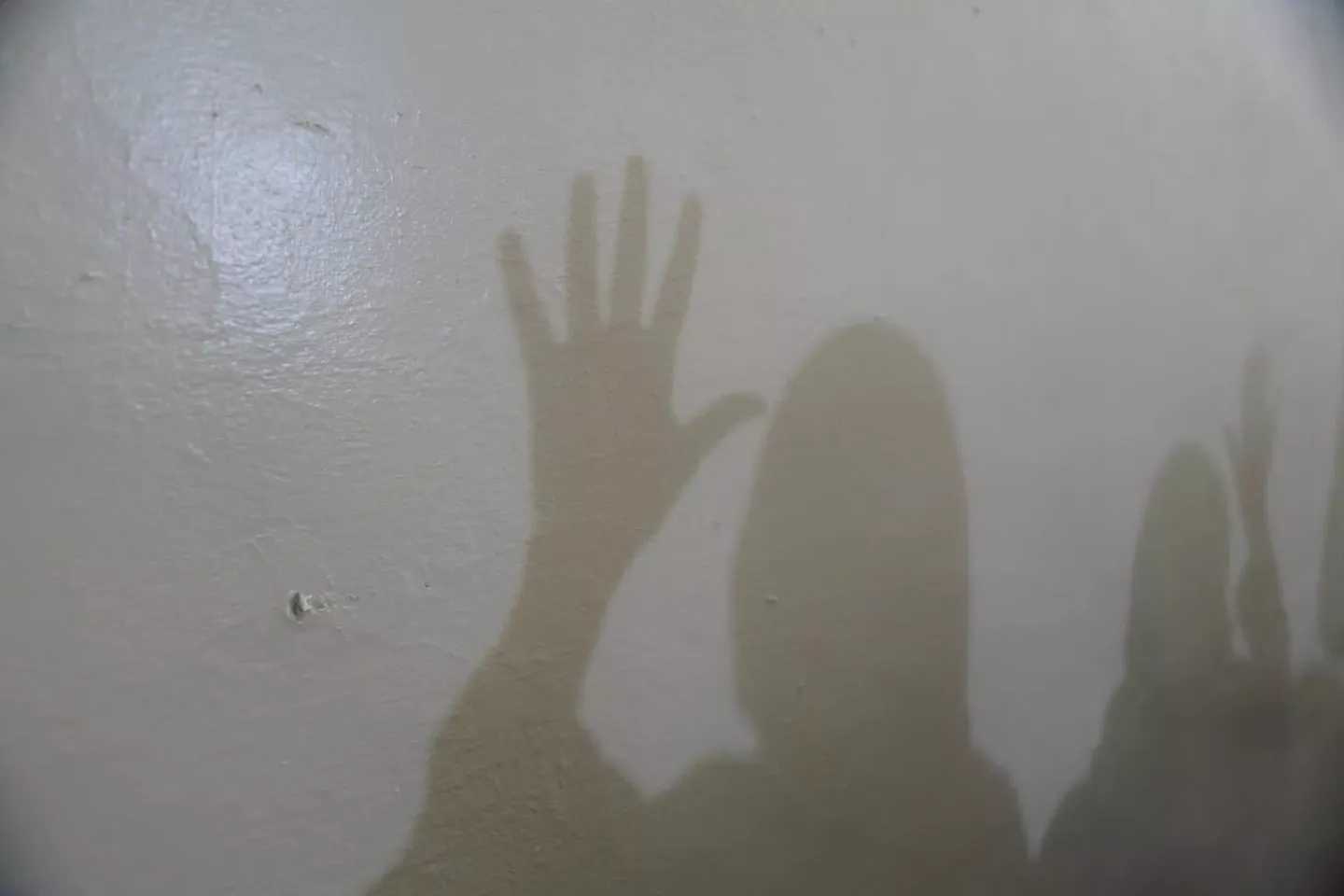 Sudan. Shadows of frontline workers at a women-led organization working on gender-based violence and child protection are seen on a wall.