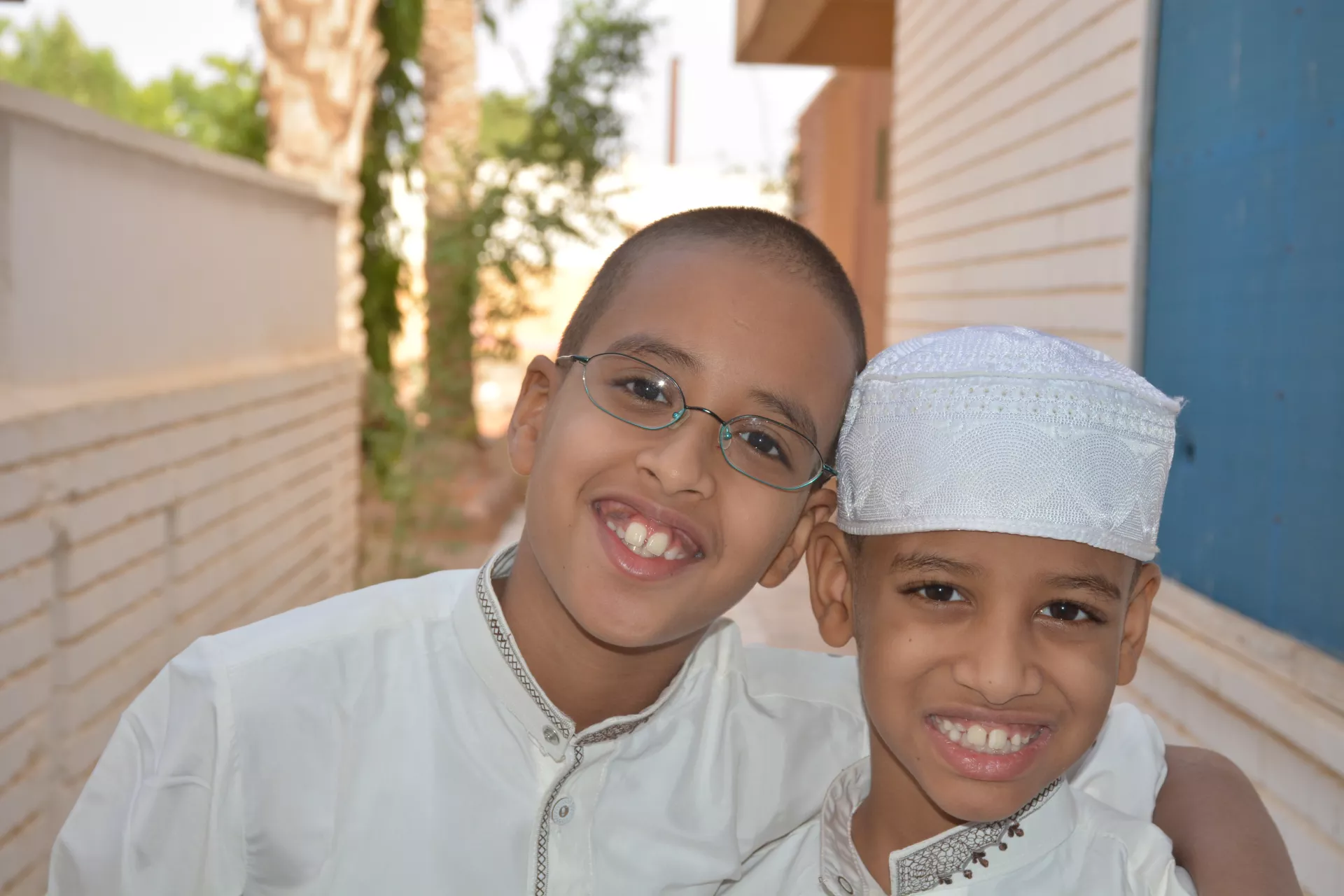 Two boys in white smiling at camera