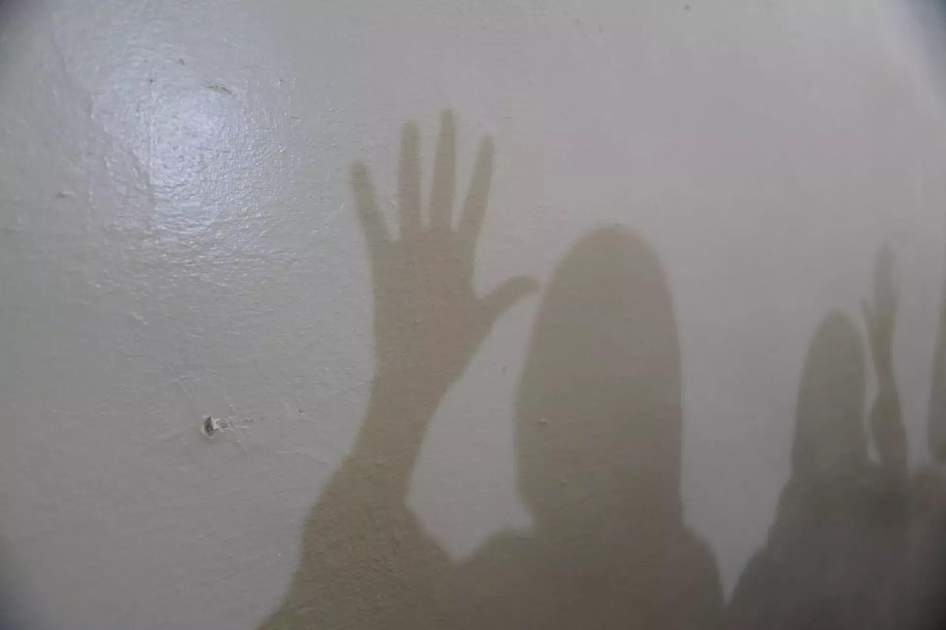 Sudan. Shadows of frontline workers at a women-led organization working on gender-based violence and child protection are seen on a wall.
