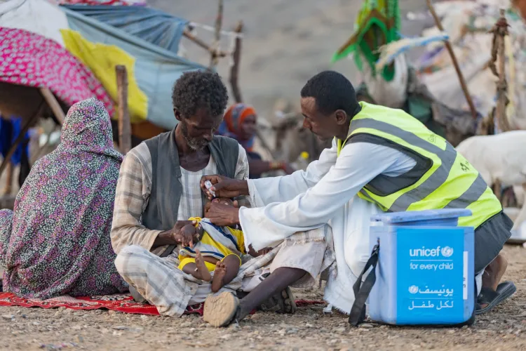 A vaccinator gives a child polio drops.