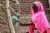 Girl with pink hijab washes hand using tippy tap