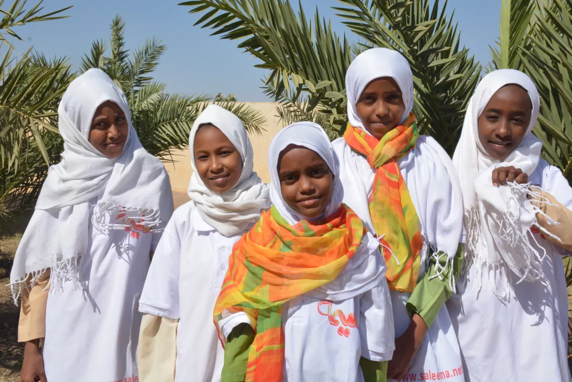 Girls smile at camera with Saleema scarves