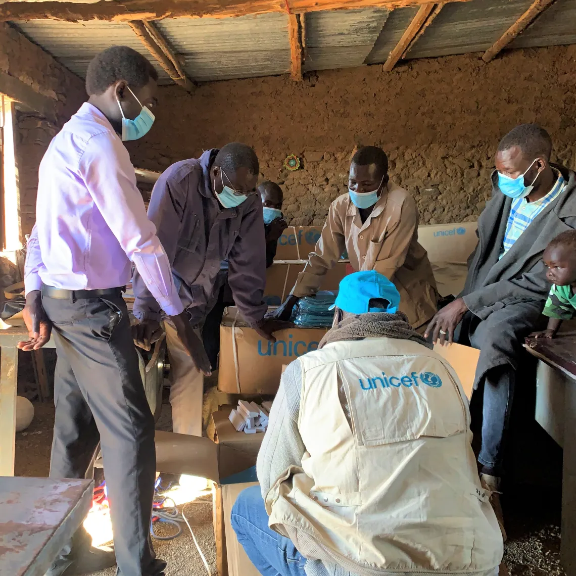 Volunteer teachers in a fifth grade classroom, where all the students are sitting on stones.  