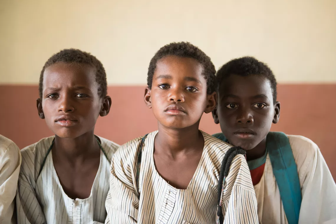 three boys look at the camera