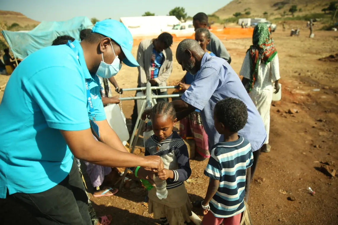 UNICEF Staff giving girl safe drinking water