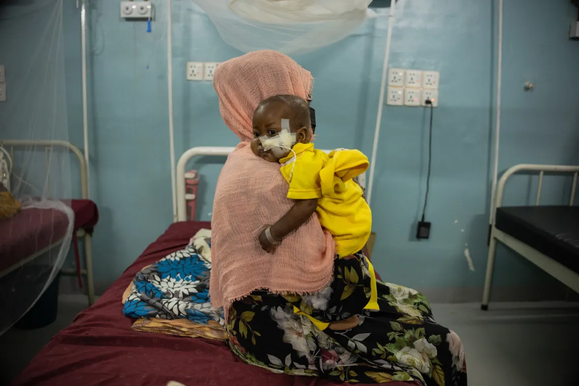  Mehad cuddles her son Muhialdeen Mohammad, 15 months who is suffering from severe acute malnutrition and admitted in the stabilization centre in Albuluk hospital in Khartoum State.