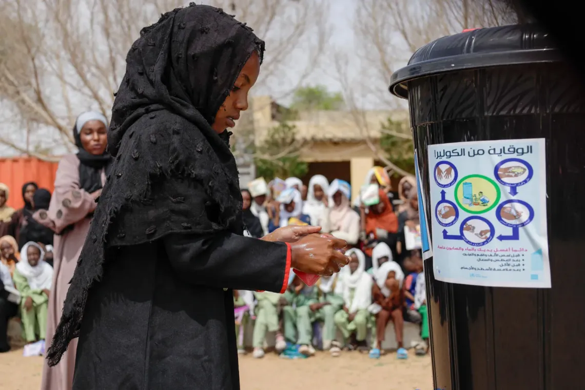 a pupil demonstrates effective hand washing with soap and water at a morning assembly in Uhud Basic School in Nyala, South Darfur.