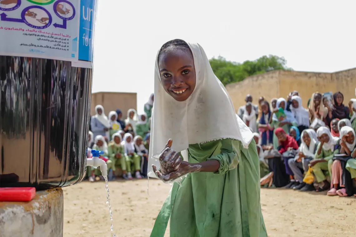 Ten-year-old Amna demonstrates how to wash hands effectively with soap and water during a morning assembly at Uhud Basic School in Nyala, South Darfur.