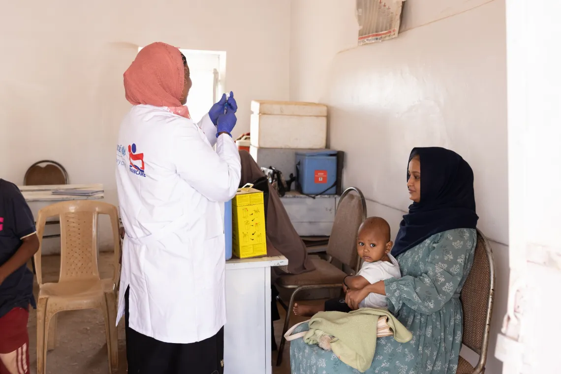 A vaccinator prepares to immunize children at Alwehida Primary Healthcare Centre (PHC) in Sennar State.