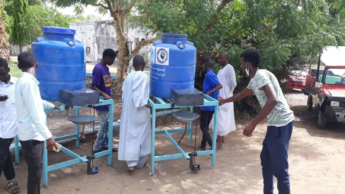 Youth at solar-powered handwashing station