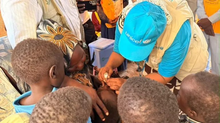 A UNICEF staff gives a child polio drops during a response campaign.