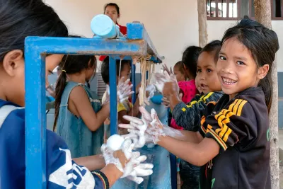 A group of schoolchildren wash their hands