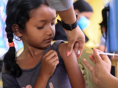 A girl receives an injection with a syringe. 