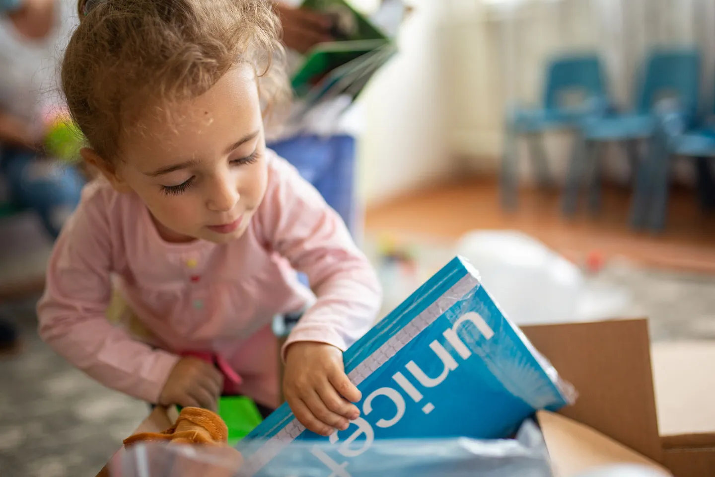 A little girl trying to unbox ECD kits