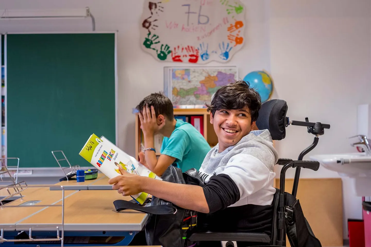 16-year-old Sajad Al-Faraji, who uses a wheelchair, smiles while sitting in a school class in the Heitzing district of Vienna, Austria.