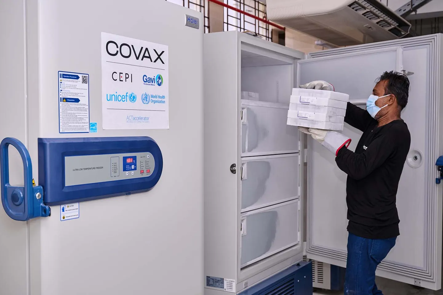 In Bangladesh, a health worker takes boxes containing COVID-19 vaccines from a ultra-low temperature freezer delivered by UNICEF through COVAX.