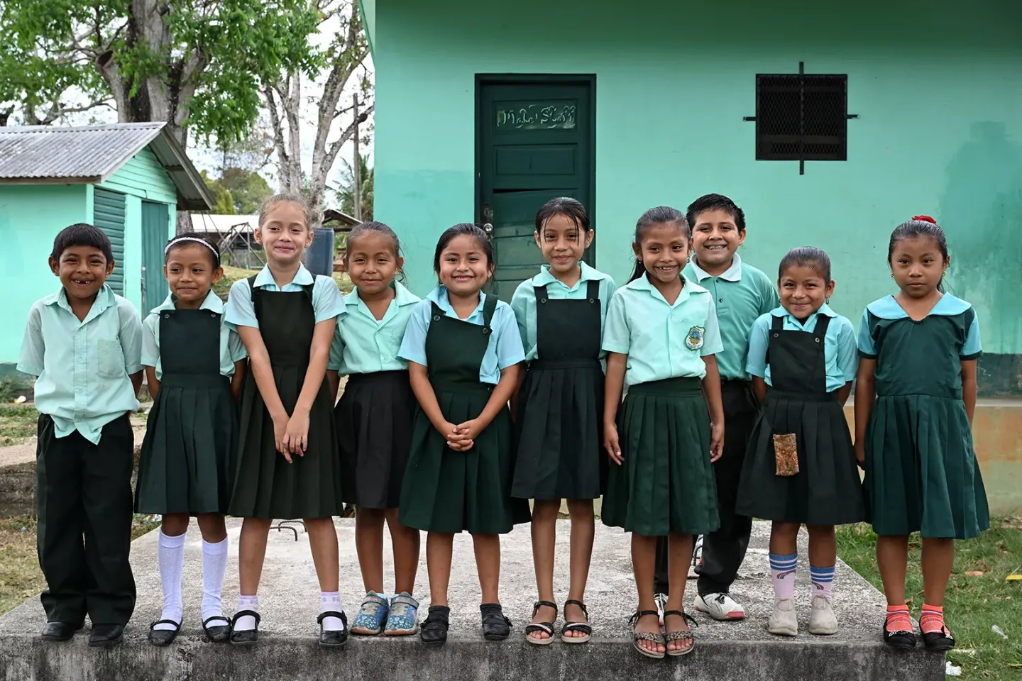 School children smiling for a photo. 