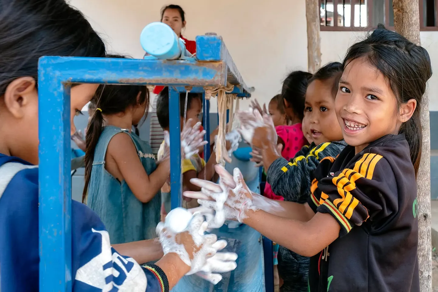 A group of schoolchildren wash their hands