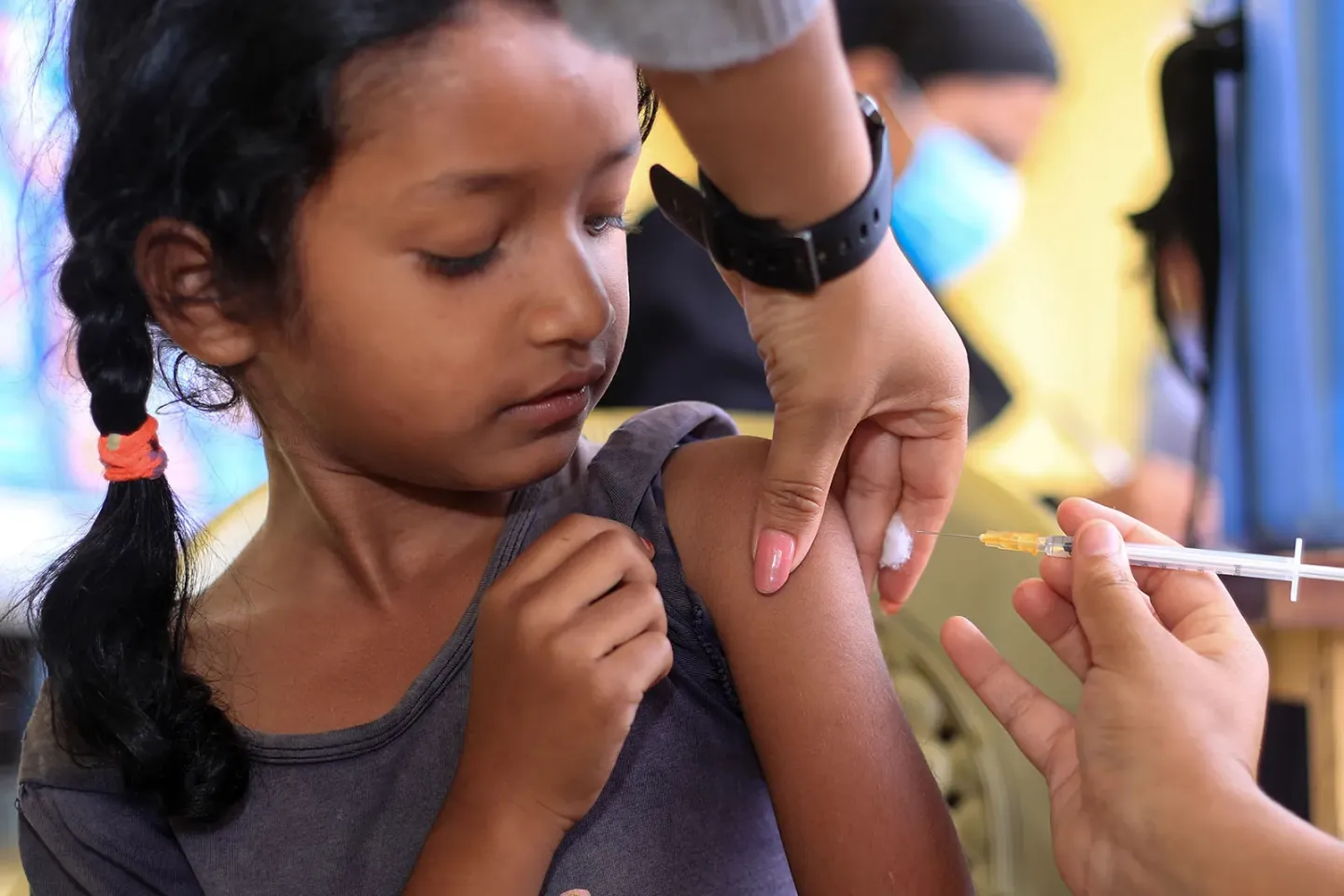 A girl receives an injection with a syringe. 