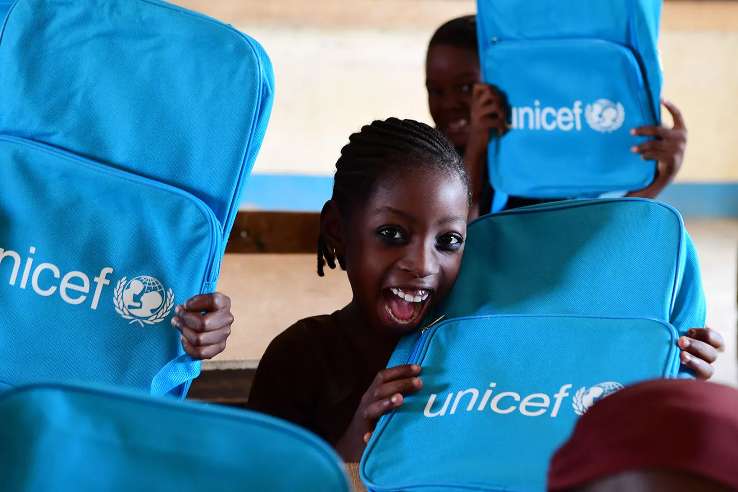 A girls is happily showing her new UNICEF school backpack in Niger. 