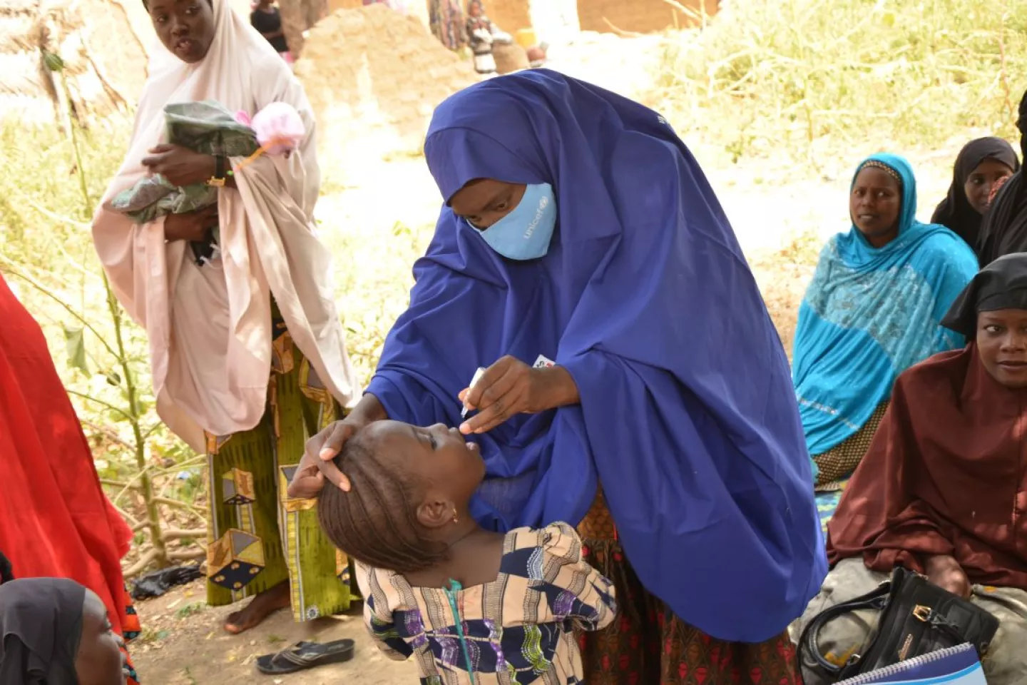 Zahariyya Hamza immunizing a little girl against polio at a birth ceremony.