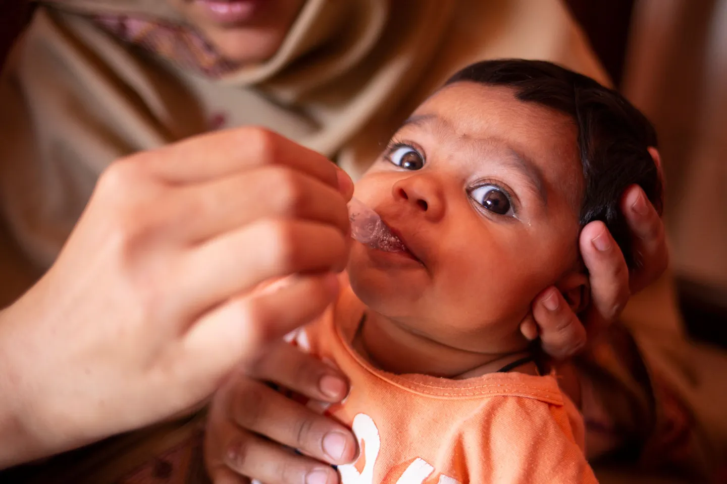 A child receives a dose of the rotavirus vaccine