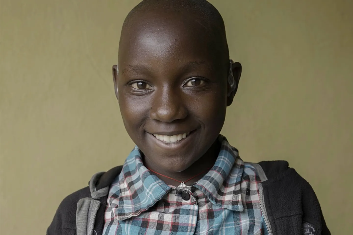Pascaline smiles after testing her hearing aids for the first time, speaking easily with her mother.