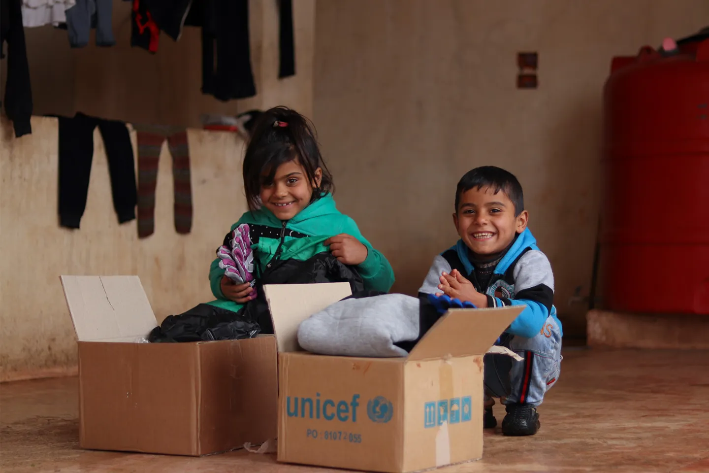 A boy and a girl opening supply packages