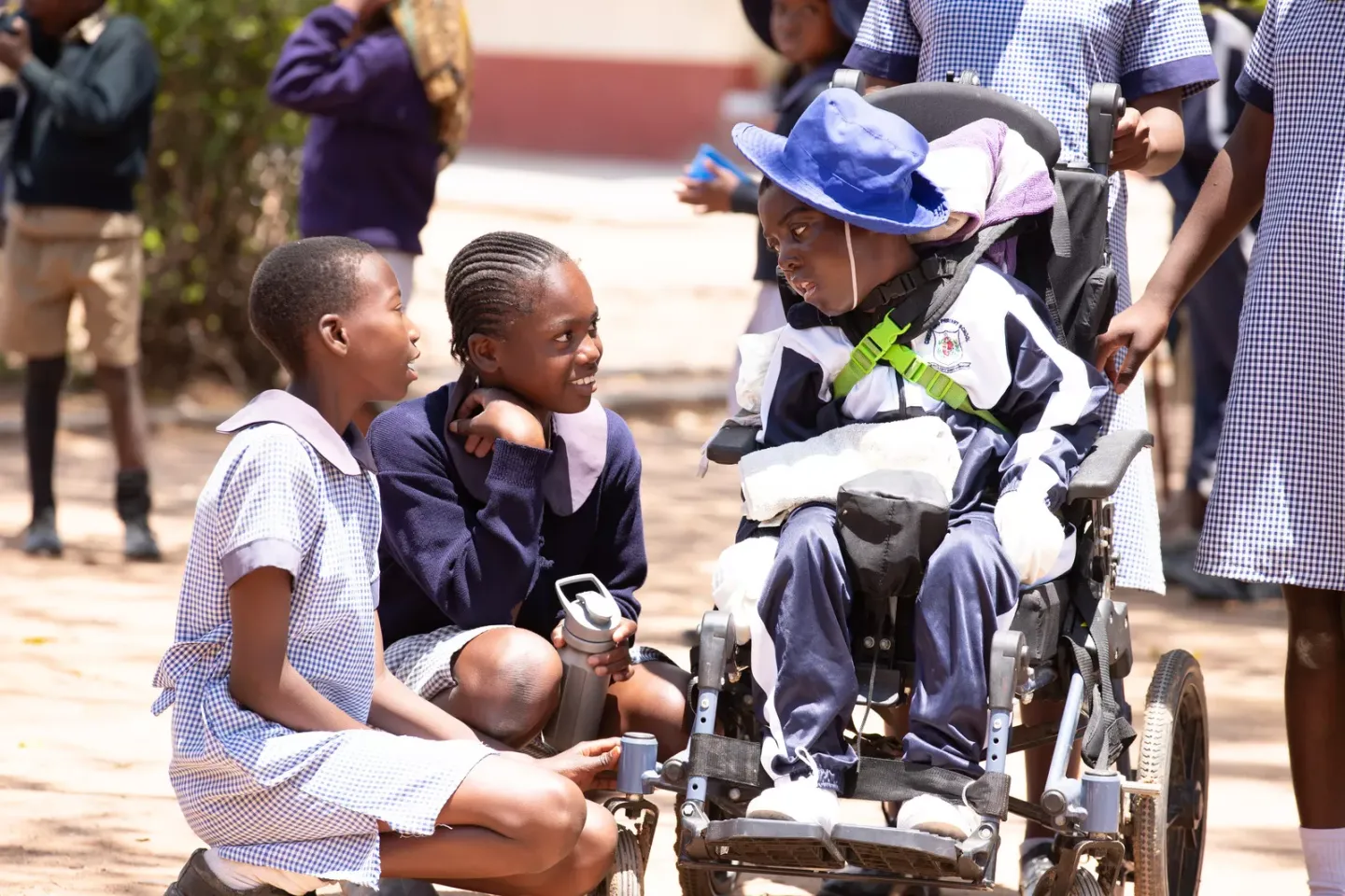 Young girl in wheelchair chatting with classmates.
