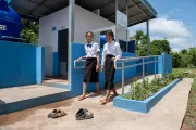 Two female students walk out of the bathroom.