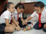 School children playing with LEGO bricks.