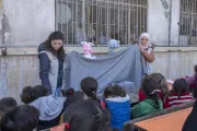 UNICEF staff playing with puppets in front of children